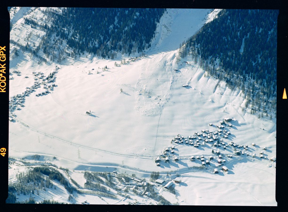 Zwischen Ritzingen und Glurigen steht die 'Fäudkapäue' (Feldkapelle) als einziges Gebäude trotzig im Auslaufgebiet der 'Löuwene'. Die auch als Muttergotteskapelle bekannte Wallfahrtskapelle wurde 1592 erstmals erwähnt. Im Februar 1807 war das Gotteshaus von einer Lawine zerstört und wiederaufgebaut worden; 1999 hat die ‘Löuwene’ aber ’nur’ den Skilift von Gluringen zerstört. Aufnahmerichtung: ESE, 25. 02. 1999, 16:00; Titel der Aufnahme: GLURINGEN/ RITZINGEN; Goms, Wallis Kameramodell: Expression 11000XL